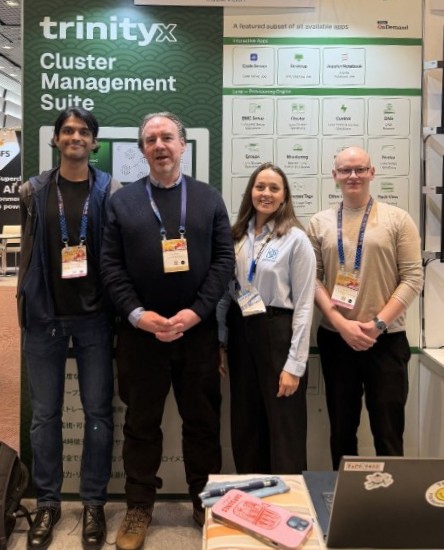 Four people standing at tech booth display.