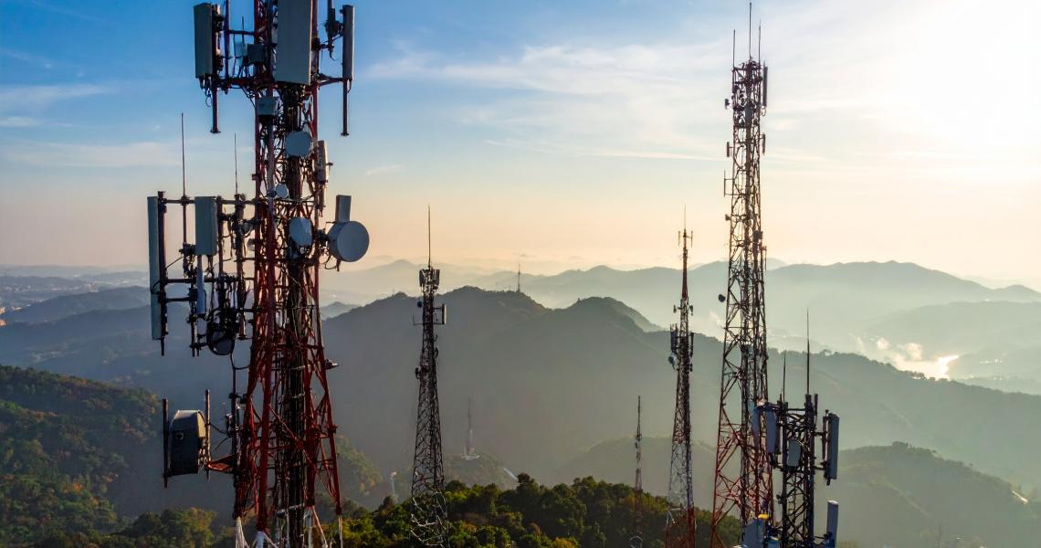 Telecommunication towers on mountain at sunrise.