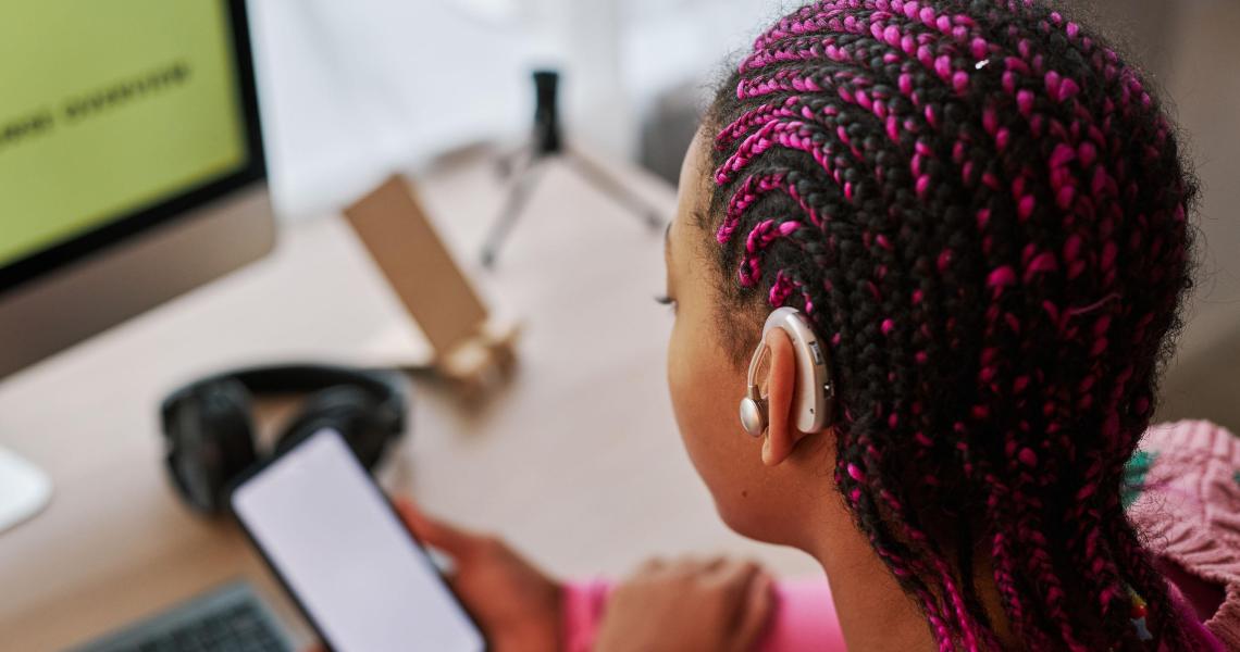 Person at a computer with an audio device